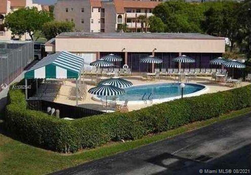 Outdoor swimming pool with umbrellas and lounge chairs.