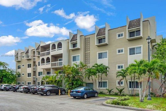 Front view of a multi-story apartment building with balconies.