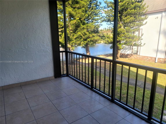 View from a balcony overlooking trees and a pond.