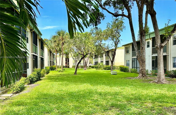 View of residential buildings with surrounding greenery and trees.