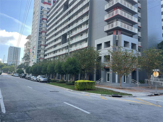 Front view of a modern multi-story residential building with balconies.