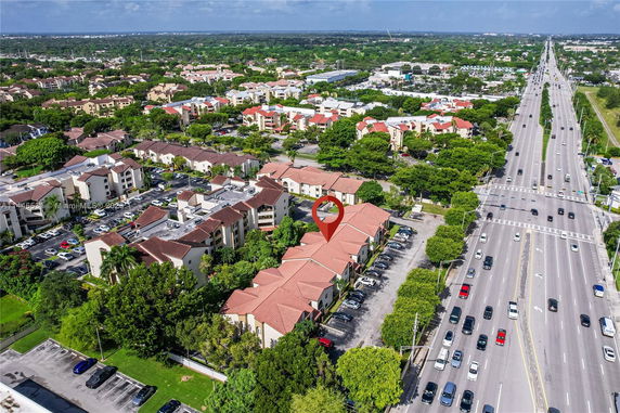 Aerial view of residential buildings in a suburban area alongside a main road.