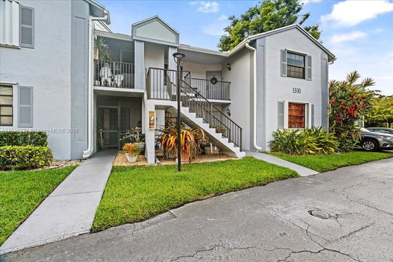 Front view of a two-story apartment building with external stairs.