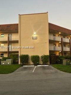 Front view of a multi-story building with balconies and a flat roof.