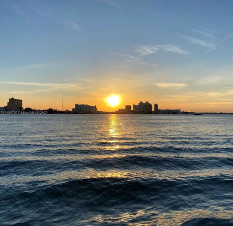 Sunset view over water with buildings in the background.