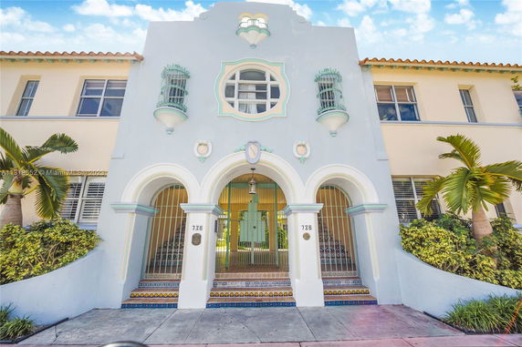 Front view of a two-story building with decorative arches and pastel colors.