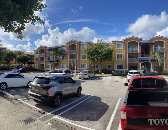 Front view of a three-story apartment building with balconies.