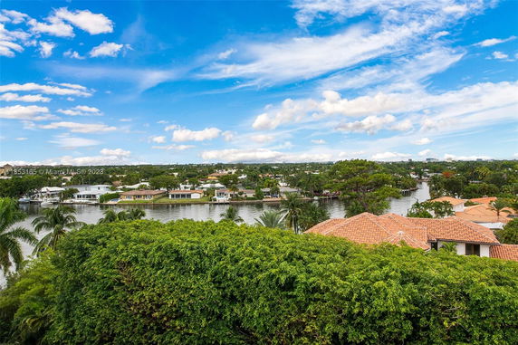 Panoramic view of houses with orange rooftops near a waterway.