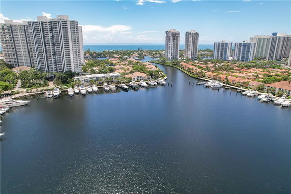 Panoramic view of waterfront high-rise buildings with docked boats.