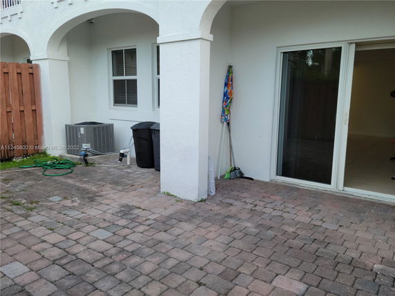 View of the back or side elevation of a house with sliding glass doors and arched architecture.
