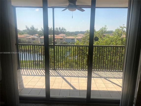 View from an apartment balcony overlooking nearby houses and greenery.