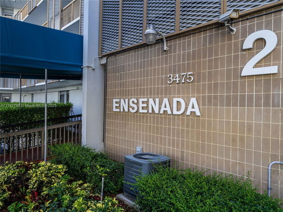 Facade of a building with the name Ensenada and number 2 displayed on a tiled wall.