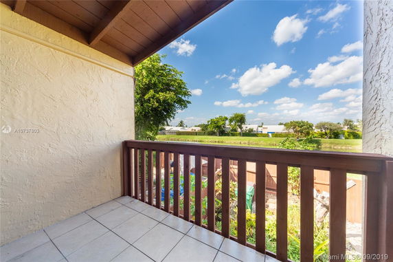View from a balcony overlooking greenery and neighboring houses.