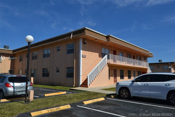 Front view of a two-story building with an external staircase.