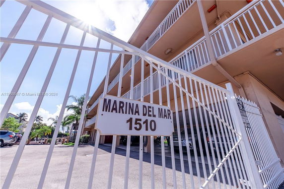 Front view of a multi-story building with a gated entrance.