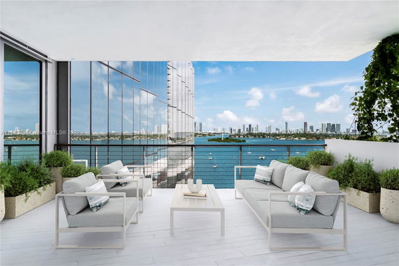 Outdoor seating area with a view of a city skyline and body of water.