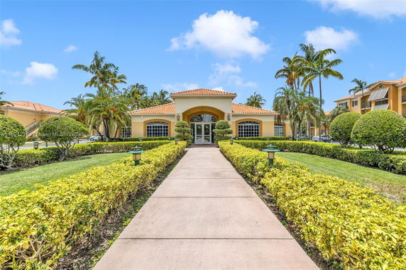 Front view of a building with a tiled roof and symmetrical landscaping.