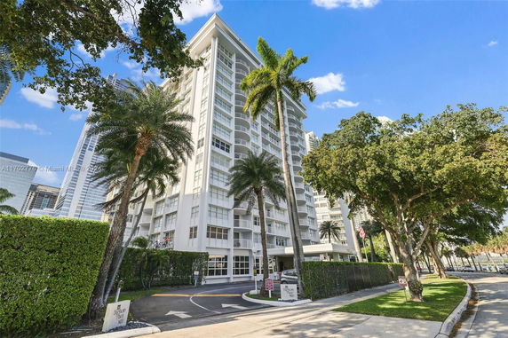 Front view of a high-rise residential building with balconies and large windows.