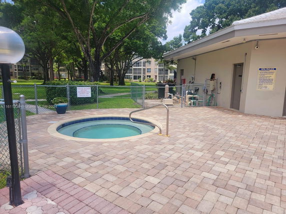Outdoor area with a small circular pool and adjacent building.