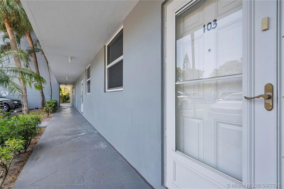 Exterior walkway of a building with doors and windows.