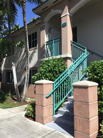 Front view of a two-story house with a staircase leading to the entrance.