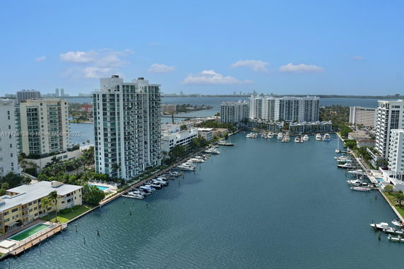 View of high-rise buildings and a marina with boats along a waterfront.