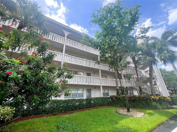 Front view of a multi-story residential building with balconies and white railings.
