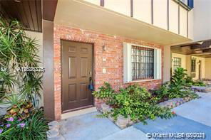 Front view of a house with a brick facade and a brown door.