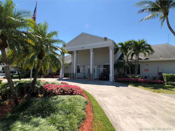 Front view of a building with a columned entrance and landscaped surroundings.