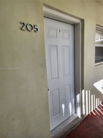 Apartment entrance with white door and unit number 205.