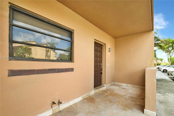 Front view of an entrance with a brown door and a window.