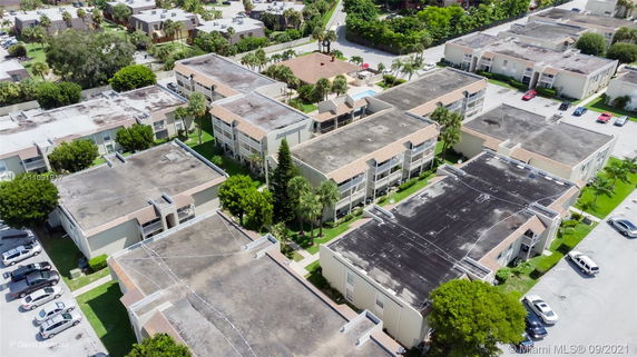 Aerial view of a residential complex with multiple two-story buildings surrounded by greenery and parking areas.