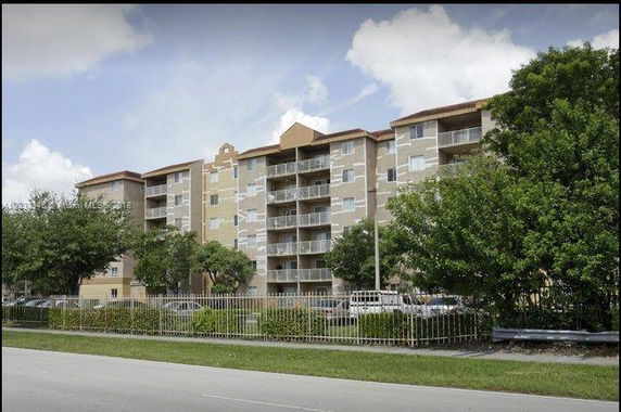 Front view of a multi-story apartment building with balconies.