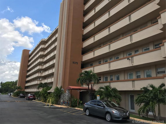 Front view of a multi-story residential building with balconies.