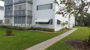 Side view of a multi-story building with verandas and window awnings.