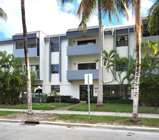 Front view of a three-story apartment building with balconies.