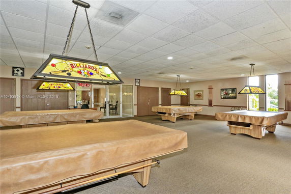 Indoor billiards room with pool tables and decorative lighting.