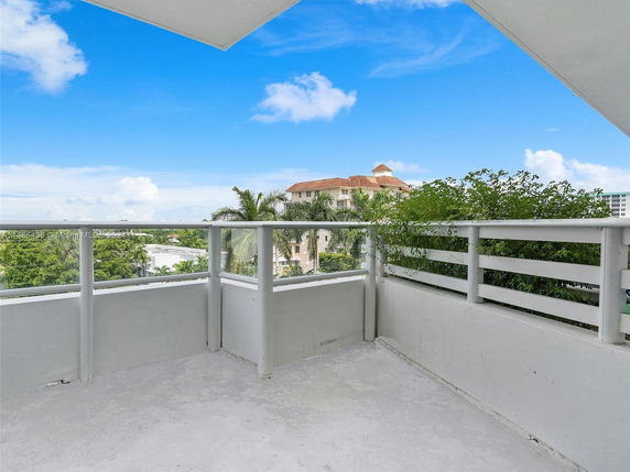 Balcony view with surrounding buildings and greenery.