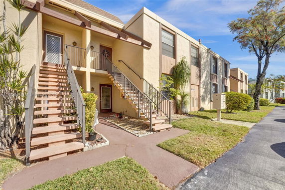 Front view of a two-story apartment complex with exterior stairs.