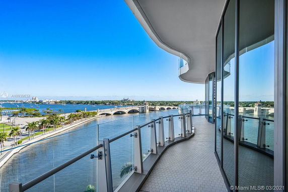 Balcony view from a high-rise building overlooking a body of water and a bridge.