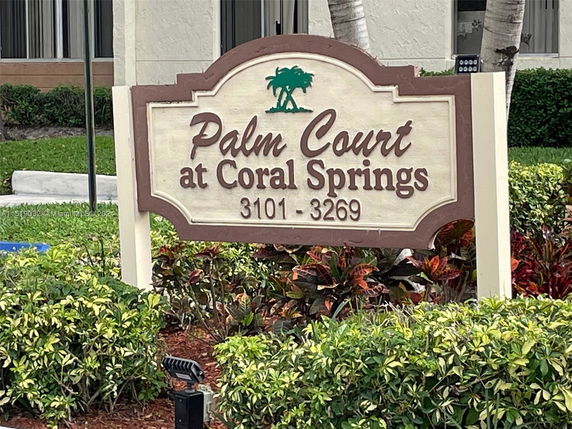 Front view of a building with a sign reading 'Palm Court at Coral Springs 3101 - 3269'.