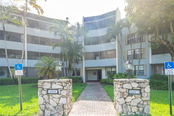 Front view of a three-story apartment building with a stone entrance.