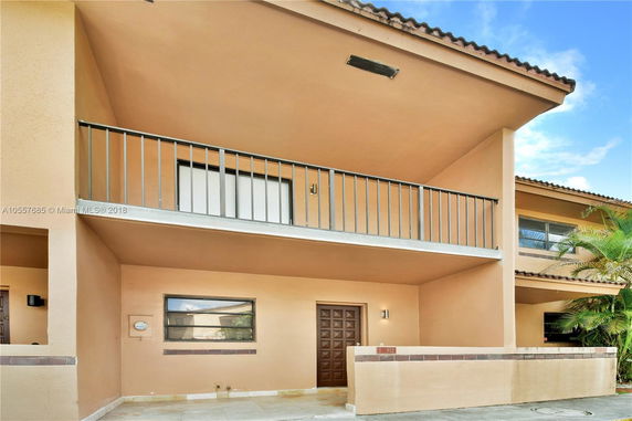 Front view of a two-story house with a balcony and garage.