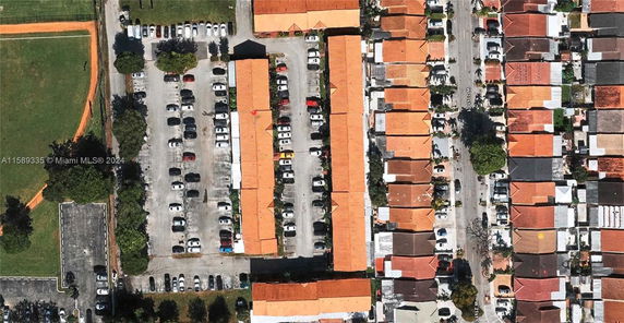 Aerial view of residential area with parking spaces between buildings.
