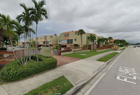 Front view of a multi-story residential building complex with gated entrance.