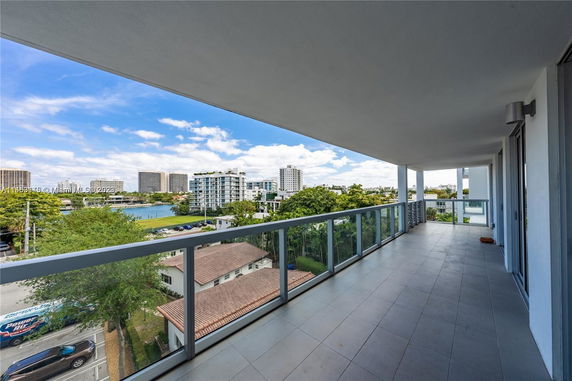 Panoramic view from a large balcony overlooking cityscape and water.