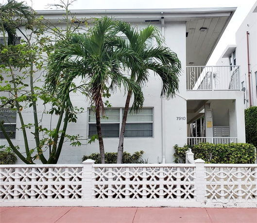 Front view of a two-story building with a decorative white fence and a balcony.