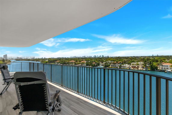 Panoramic view from a balcony overlooking a waterway and cityscape.