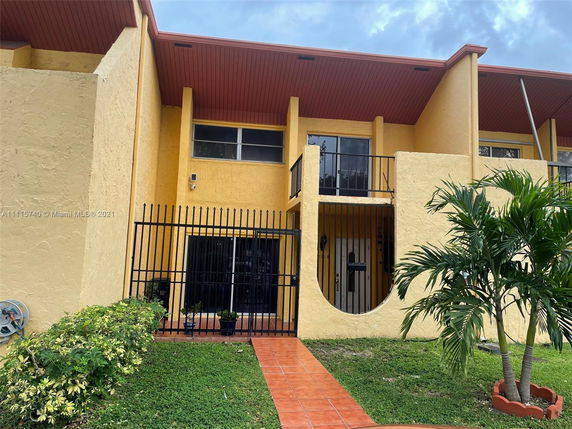 Front view of a two-story house with a gated entrance and balcony.