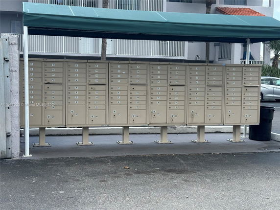 Multiple mailboxes under a green canopy.